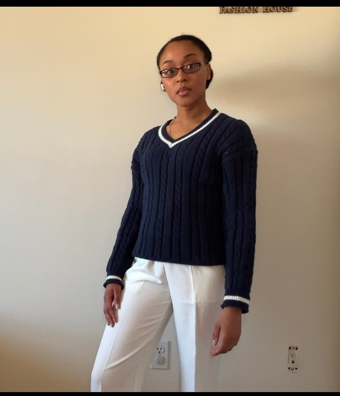 Navy blue cable-knit sweater with white wide-leg pants