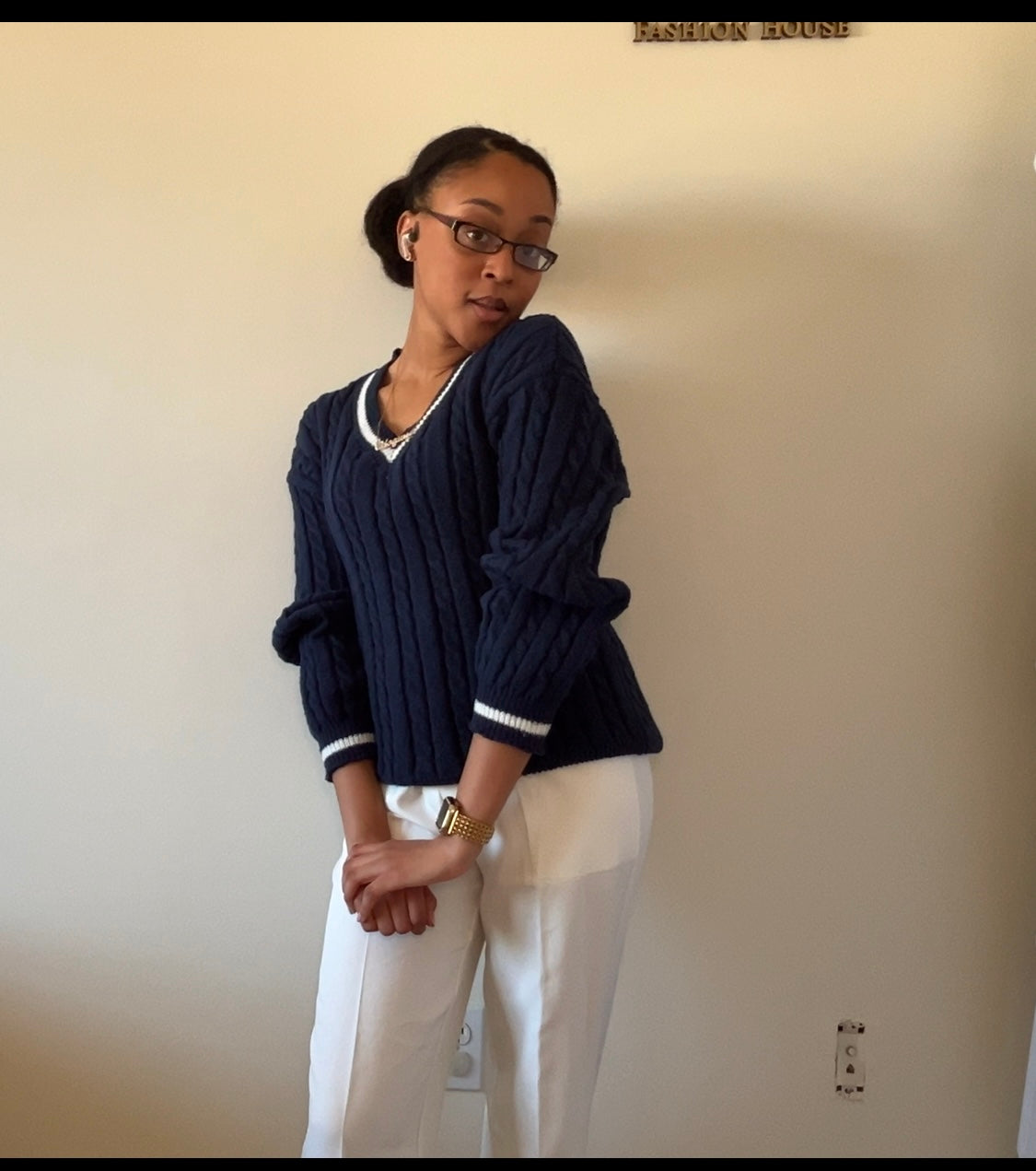 Navy blue cable-knit sweater with white wide-leg pants